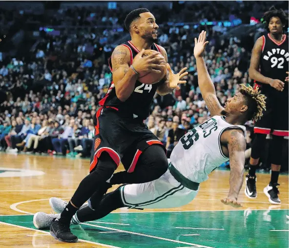  ?? — THE ASSOCIATED PRESS FILES ?? Toronto Raptors’ Norman Powell runs over Boston Celtics’ Marcus Smart on his way to the basket during the second half of the Toronto Raptors’ 101-94 win over the Boston Celtics on Friday. Powell had 20 points and five steals in a rare start.