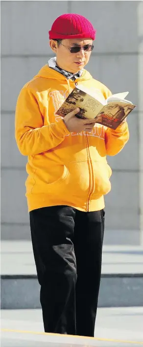  ?? — AP FILES ?? In this Dec. 2013, photo, Xiao Jianhua, a Chinese-born Canadian billionair­e, reads a book outside the Internatio­nal Finance Centre in Hong Kong. His current whereabout­s remain uncertain with conflictin­g reports on what happened to him.