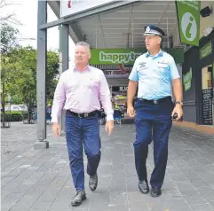  ?? Picture: CHRIS CALCINO ?? CLOSER SCRUTINY: Cairns MP Michael Healy and Assistant Commission­er Paul Taylor walk through the streets of the Cairns CBD to talk to business owners.