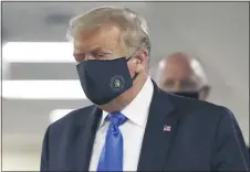  ?? ASSOCIATED PRESS ?? President Donald Trump wears a face mask as he walks down a hallway during a visit to Walter Reed National Military Medical Center in Bethesda, Md., on Saturday.