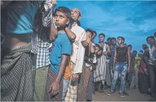  ?? PAULA BRONSTEIN GETTY IMAGES ?? Rohingya refugees wait in line for humanitari­an aid in a refugee camp in Bangladesh on Monday.