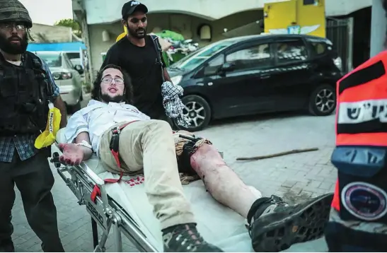  ??  ?? Paramédico­s atienden a un joven judío tiroteado en Lod