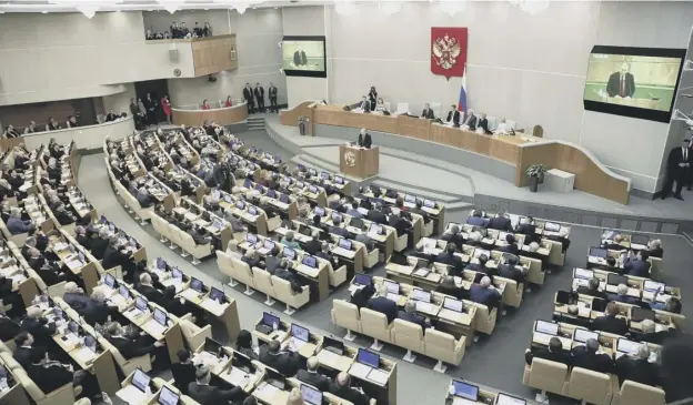  ?? PICTURES: PAVEL GOLOVKIN/PA ?? 0 Vladimir Putin addresses Russia’s lower house of parliament, the Duma, which approved the change with no votes against