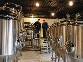  ??  ?? Patrick Howard and James Williams, co-founders of Southern Ohio Brewing in Beavercree­k, received delivery of their brewing system last week.