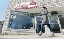  ?? DAN JANISSE/The Windsor Star ?? A pedestrian walks by the Velvet Restaurant in Windsor. The res
taurant will close its doors for good on Dec. 4 after 90 years.