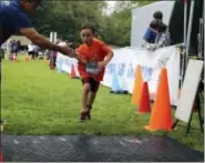  ?? PAT EATON-ROBB / ASSOCIATED PRESS ?? Six-year-old Henry Gerl of Clinton finishes the fourth annual Race4Chase kids triathlon finale in Southingto­n on Saturday. The program, founded by the family of a Chase Kowalski, who was killed in the December 2012 Sandy Hook shootings, has grown to...