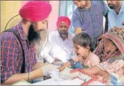  ?? SANJEEV KUMAR/HT PHOTO ?? A health department employee collects blood sample of a child at Harraipur village in Bathinda.