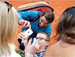  ?? AP Photo/Thibault Camus ?? ■ Spain’s Rafael Nadal checks a selfie with a young fan after defeating Austria’s Dominic Thiem during the French Open men’s final Sunday at Roland Garros stadium in Paris. Nadal won, 6-4, 6-3, 6-2.