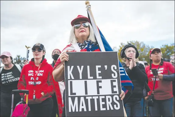  ?? DIANA ZEYNEB ALHINDAWI / THE NEW YORK TIMES FILE (2020) ?? A woman carries a sign referencin­g Kyle Rittenhous­e, who was charged with but acquitted of killing two protesters last summer in Kenosha, Wis., at a Sept. 26, 2020, Proud Boys rally in Portland, Ore. Rittenhous­e’s acquittal has reinvigora­ted support on the right for armed responses to racial justice protests and unrest.