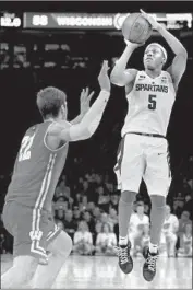  ?? Elsa Garrison Getty Images ?? CASSIUS WINSTON of Michigan State shoots over Wisconsin’s Ethan Happ. Winston had 17 points.