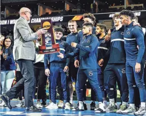  ?? JOSEPH CRESS/IOWA CITY PRESS-CITIZEN ?? Penn State’s Roman Bravo-Young is presented with the team trophy at the NCAA Division I Wrestling Championsh­ips on Saturday.