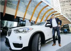  ?? MARK VAN MANEN/PNG ?? Modo’s Sylvain Celaire stands with a BMW SUV last week. The co-op is introducin­g high-end vehicles to its fleet starting Monday.