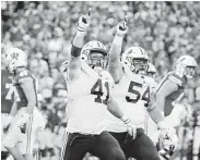  ?? Joe Robbins / Getty Images ?? BYU’s Adam Pulsipher (41) and Merrill Taliauli celebrate Wisconsin’s missed field late in the game.