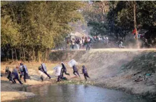  ?? REUTERSPIX ?? ... Nepalese riot police run for cover as Madhesi activists hurl stones at them in Saptari district on Monday. Security forces opened fire at a political rally on Monday, killing three protesters and injuring more than a dozen, in the southeaste­rn town...