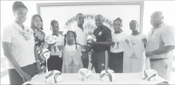  ??  ?? President’s College Physical Education Teacher Willon Cameron collects the donation in the presence of students and staff of the school from GFF’S Youth Developmen­t Officer (YDO) Bryan Joseph (fourth from right).