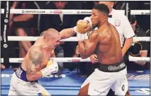  ?? ?? Oleksandr Usyk of Ukraine (left), throws a punch at Anthony Joshua of Britain during their WBA (Super), WBO and IBF boxing title bout at the Tottenham Hotspur Stadium in London. (AP)