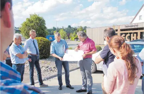  ?? FOTO: WOLFGANG LUTZ ?? Markus Wiehl vom Büro Funk aus Riedlingen (am Plan rechts) und Ortsbaumei­ster Manfred Fiederer erläutern dem Gremium die geplanten Vorhaben im Industrieg­ebiet Brühl in Binzwangen.