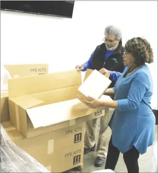  ?? Brodie Johnson • Times-Herald ?? Forrest City Mayor Larry Bryant and City Clerk Derene Cochran open boxes of personal protective equipment (PPE) that are available to the public at city hall. The city has received several cases of the supplies that are free to anyone who wants to pick up a box. Each of the boxes contains sanitizing wipes, facemasks, hand sanitizer and liquid soap.