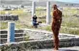  ??  ?? A visitor sits next the statue “Water” by renowned British artist Antony Gormley, part of his exhibition “Sight” at the archeologi­cal site of the island of Delos.