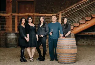  ??  ?? At Home Moe Momtazi in the cellar at Maysara Winery, with (from left) his daughters, Naseem, Hanna, and Tahmiene (the winemaker), a bottle of his Asha pinot noir, and his wife, Flora.