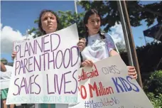  ?? JOE RAEDLE, GETTY IMAGES ?? Sarah Stumbar, left, joins a June 28 protest at Sen. Marco Rubio’s office against the Senate proposal to make cuts to Medicaid.