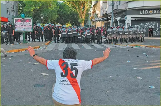  ??  ?? DISTURBIOS. Tras la suspensión del partido, hubo corridas y incidentes en los alrededore­s del Monumental entre hinchas y la policía.