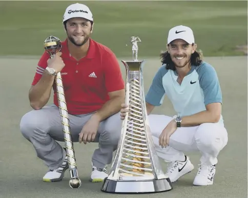  ??  ?? 0 Jon Rahm (left) and Tommy Fleetwood hold the trophies they won at Jumeirah Golf Estates in Dubai.