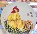  ??  ?? Painting by Dr. Pauline Santiago on a porcelain plate represents the Year of the Rooster this 2017.