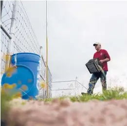  ?? GREGORY BULL/AP ?? Migrant rights activist Eduardo Canales carries jugs of water to a water drop this month in Falfurrias, Texas. The water is for migrants who enter the region.