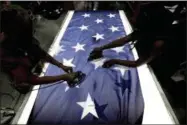  ?? GERRY BROOME — THE ASSOCIATED PRESS ?? Employees Lottie Penick, left, and Melissa Hodnett iron stars onto a United States flag at Annin Flagmakers in South Boston, Va., on Wednesday, July 6, 2016. Ask the workers at the factory to name life’s most important things and family, work and faith...