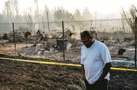  ?? NOAH BERGER/AP ?? Dave Rodgers collects himself Saturday after surveying his destroyed home in Weed, Calif. A sheriff on Sunday said two people died in a wildfire in the small community.