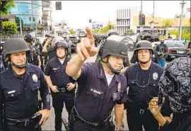  ?? Kent Nishimura Los Angeles Times ?? LAPD CHIEF Michel Moore speaks to a protester in the Fairfax district May 30. In a lawsuit, a woman says police shot her in the face with a projectile at a rally.