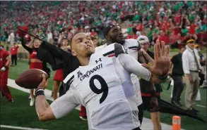  ?? Darron Cummings / Associated Press ?? Cincinnati quarterbac­k Desmond Ridder throws a football into the stands after the Bearcats defeated Notre Dame on Saturday in South Bend, Ind.