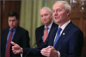  ?? The Associated Press ?? EVOLVING SITUATION: In this March 23 file photo, Gov. Asa Hutchinson, right, speaks in Little Rock. Hutchinson says he’s not ready to further ease restrictio­ns on businesses as the number of coronaviru­s cases in the state continue to spike. Hutchinson on Thursday said Arkansas’ plans to further lift restrictio­ns remains on pause after neighborin­g Texas halted its aggressive reopening of businesses.