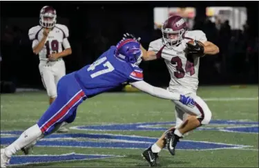  ?? ERIC BONZAR — THE MORNING JOURNAL ?? Rocky River’s Matthew Popovich (34) stiff arms his way past Bay linebacker Vladimir Miskovic (47) Sept. 29.