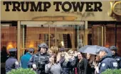  ??  ?? Passers-by stop for a selfie with a heavily armed New York police officer at the main Fifth Avenue entrance to Trump Tower in New York.