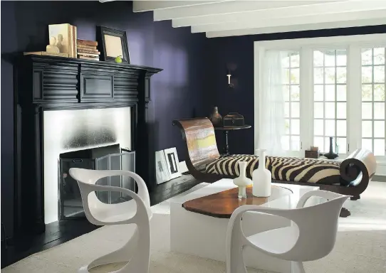  ?? PHOTOS (2) COURTESY OF BENJAMIN MOORE ?? Purple walls and an ebony-coloured fireplace mantel combine for a dramatic look that is softened by the light-coloured carpet, overhead beams and trim around the windows. The result is a stylish, modern room that manages to feel both spacious and cosy.