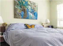  ??  ?? Like the rest of the apartment, the bedroom features artwork and teak furnishing­s. Two-tone grey/green contrastin­g walls complement the space.