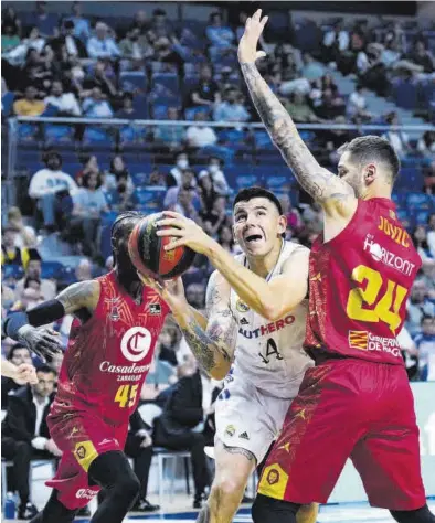  ?? EFE / BORJA SÁNCHEZ ?? Jovic y Sant-Roos tratan de impedir una canasta de Deck en el encuentro de ayer en Madrid.