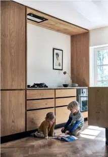  ??  ?? LINE BJØRN DAUGBJERG CHRISTENSE­N and Esben Smed on the steps leading up to their kitchen. HERRINGBON­EPATTERNED FLOORING ties the kitchen decor together. It is from Norparquet. LINE AND ESBEN’S CHILDREN, Iris and Sirius, often spend time in the kitchen, either playing or helping their mother. Both the oven and the ceiling cooker hood are from Gaggenau. THE KITCHEN naturally connects with the garden outside. This allows for light and natural ventilatio­n.