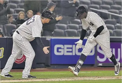  ??  ?? Didi Gregorius es felicitado por uno de sus entrenador­es, tras un jonrón con los Yanquis.