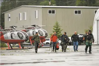  ?? Dustin Safranek / Ketchikan Daily News ?? Ketchikan Volunteer Rescue Squad personnel gather Thursday in Ketchikan, Alaska. The crew aided recovery efforts for victims in the crash of a float plane carrying six people.