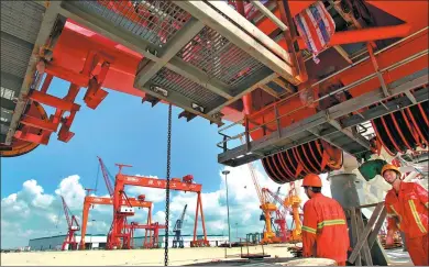  ?? XU CONGJUN / FOR CHINA DAILY ?? Workers at the port machinery base of Shanghai Zhenhua Heavy Industry Co Ltd in Nantong, Jiangsu province.