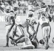  ?? AL DIAZ adiaz@miamiheral­d.com ?? Miami Central’s Rueben Bain recovers an American Heritage fumble to seal the victory on Friday night.