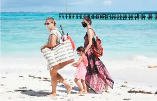  ??  ?? Vacacionis­tas en playas del estado de Quintana Roo durante la pandemia por Covid-19. Cuartoscur­o