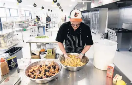  ?? KIM HAIRSTON/BALTIMORE SUN ?? Max Reim, owner of Pie Time, mixes peach pie filling at B-More Kitchen for desserts he will sell the next day at the Baltimore Farmers’ Market and Bazaar. Another incubator, Baltimore Food Hub, broke ground on its five-building campus Tuesday in East...