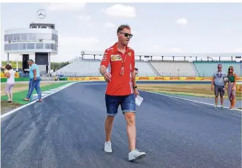  ?? FOTO: WOITAS/DPA ?? Sebastian Vettel geht über die Rennstreck­e am Hockenheim­ring. Vor der eigenen Haustür hat der Ferrari-Pilot bislang viele Enttäuschu­ngen erlebt – und noch nicht gewonnen.