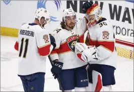  ?? JEFFREY T. BARNES — THE ASSOCIATED PRESS ?? Florida Panthers left wing Jonathan Huberdeau (11) and left wing Ryan Lomberg (94) celebrate a victory with goaltender Spencer Knight (30) following the third period of an NHL hockey game against the Buffalo Sabres, Sunday in Buffalo, N.Y.