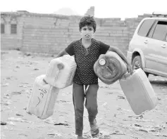  ??  ?? A Yemeni child carries empty jerrycans amid continuing wide spread disruption of water supply in the impoverish­ed coastal village on the outskirts of the Yemeni port city of Hodeidah. — AFP photo