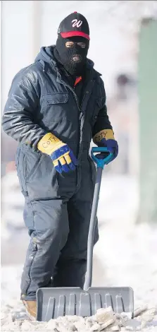  ?? DAX MELMER ?? Coty Coates dresses for extreme cold conditions as he shovels the sidewalk in front of Excess Metals in Ford City on Tuesday.